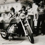 Manuela (ganz links) und Lutz (rechts) Balzer bei einer seiner Lieblingsbeschäftigungen: Motorräder bewundern. Bemerkenswert auch das T-Shirt, welches Lutz trägt.>